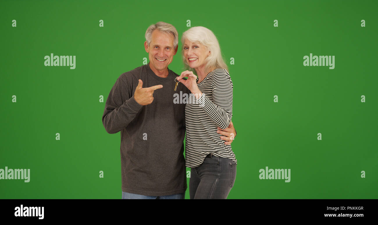 Frohes neues senior Eigenheimbesitzer mit Tasten Lächeln auf die Kamera auf Green Screen Stockfoto