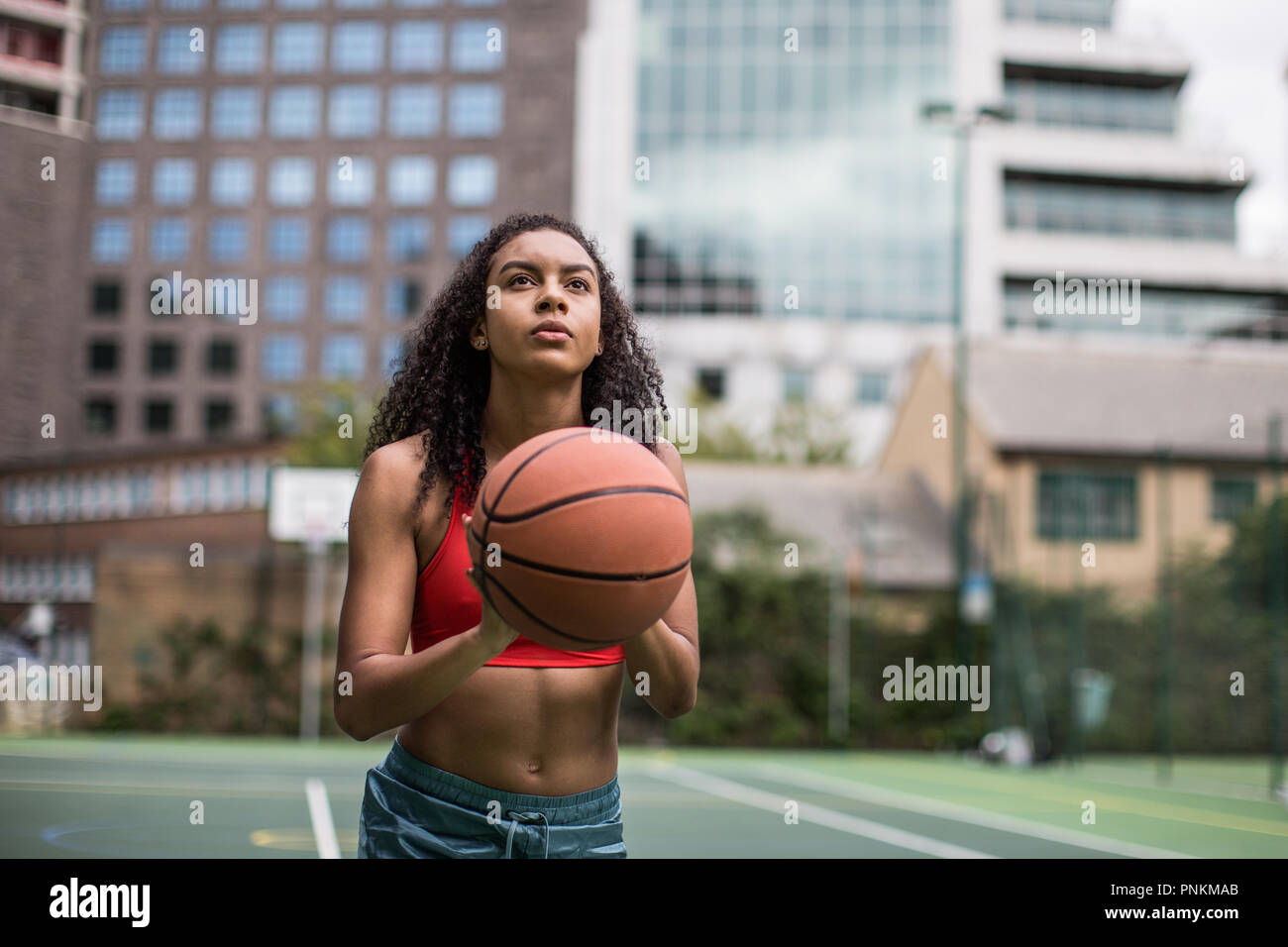 Junge Erwachsene weiblichen Basketball Player über ein Hoop schießen Stockfoto