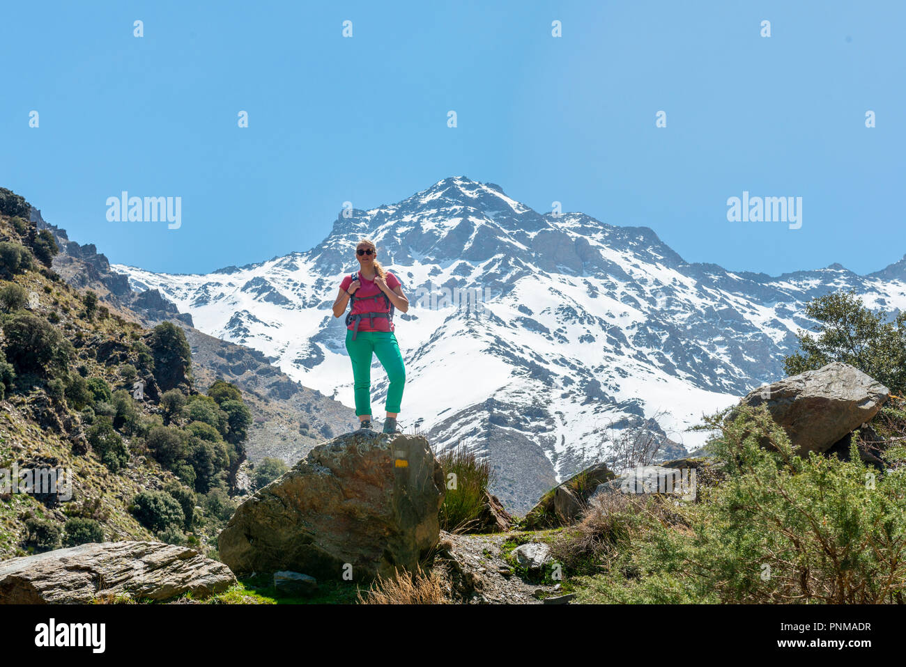 Wanderer auf einem Felsen, hinter Sierra Nevada, Snowy Mountains in Granada, Andalusien, Spanien Stockfoto