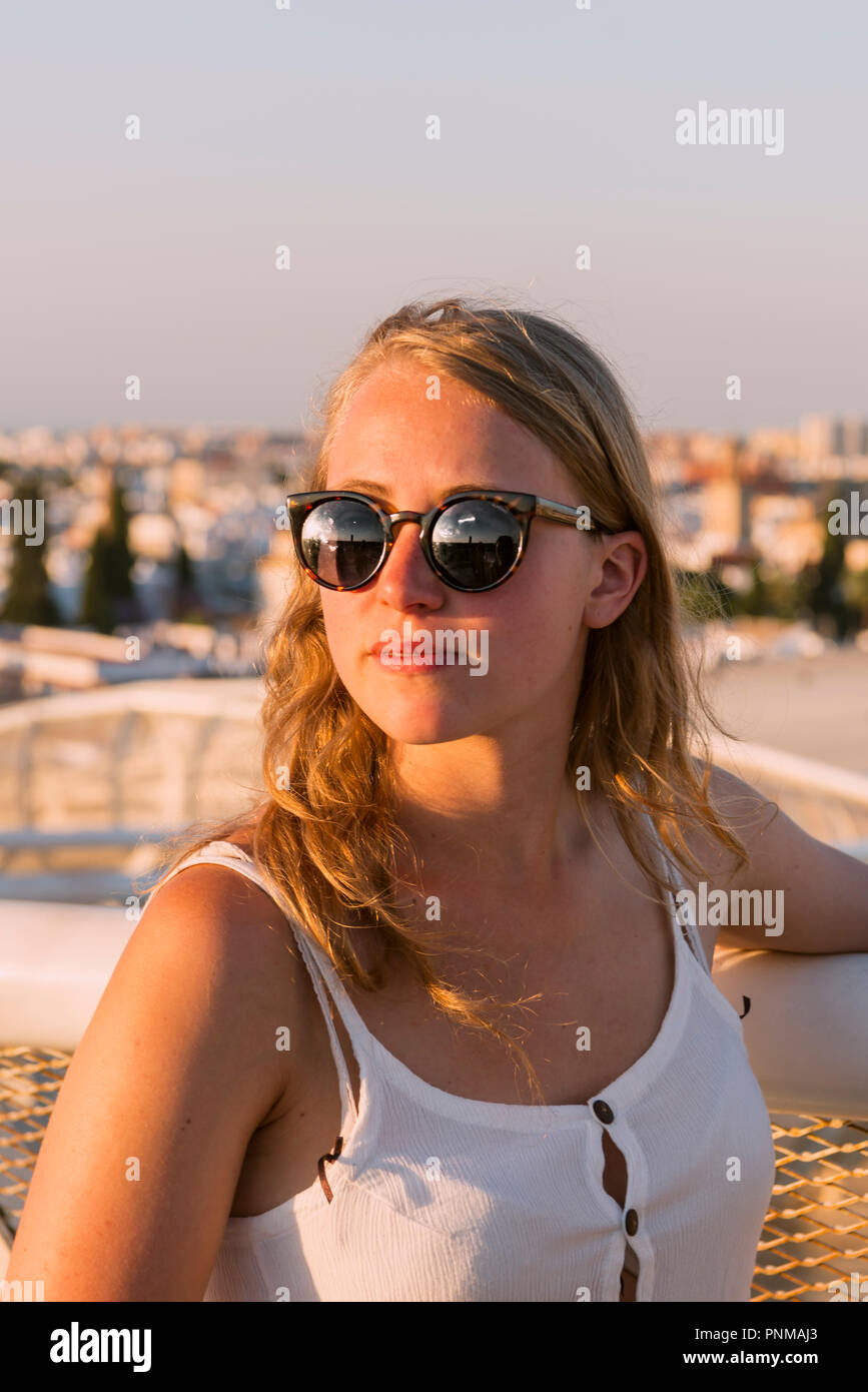 Junge Frau mit weißer Spitze und Sonnenbrille schaut in die Kamera, Plaza de la Encarnacion, hinter den Häusern, Sevilla, Andalusien Stockfoto