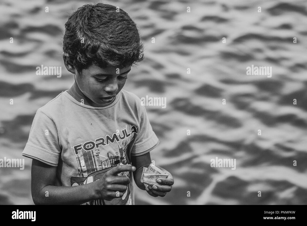 Sri Lankan armen Street kid zählen Geld in Veliko Tŭrnovo Stockfoto