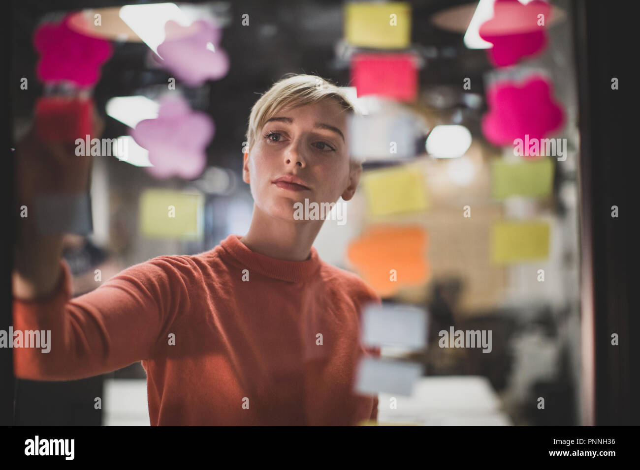 Junge Erwachsene weiblichen Brainstorming Ideen in der Nacht in einem Büro Stockfoto