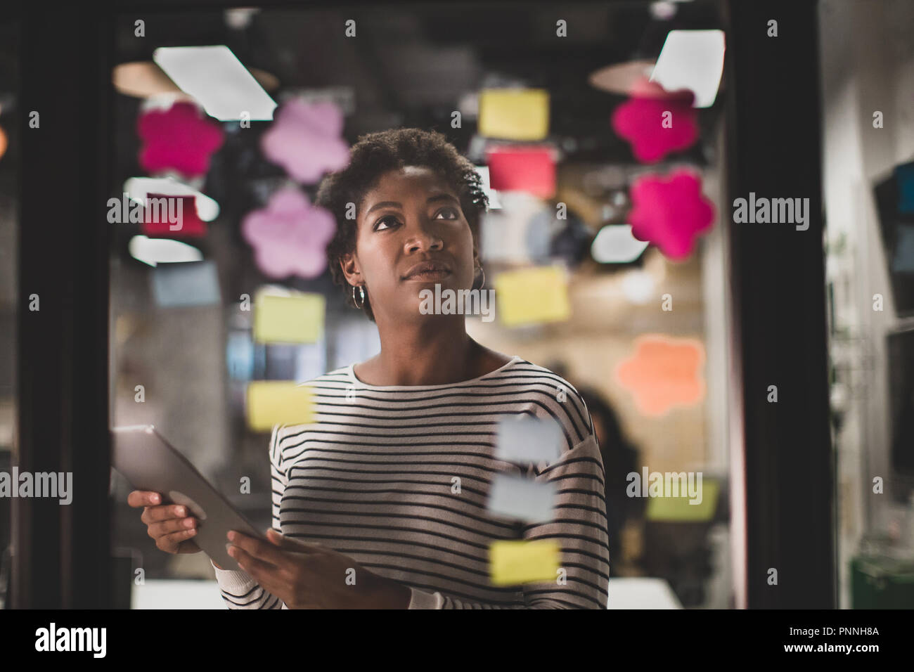 Afrikanische amerikanische weibliche Brainstorming Ideen in der Nacht in einem Büro Stockfoto
