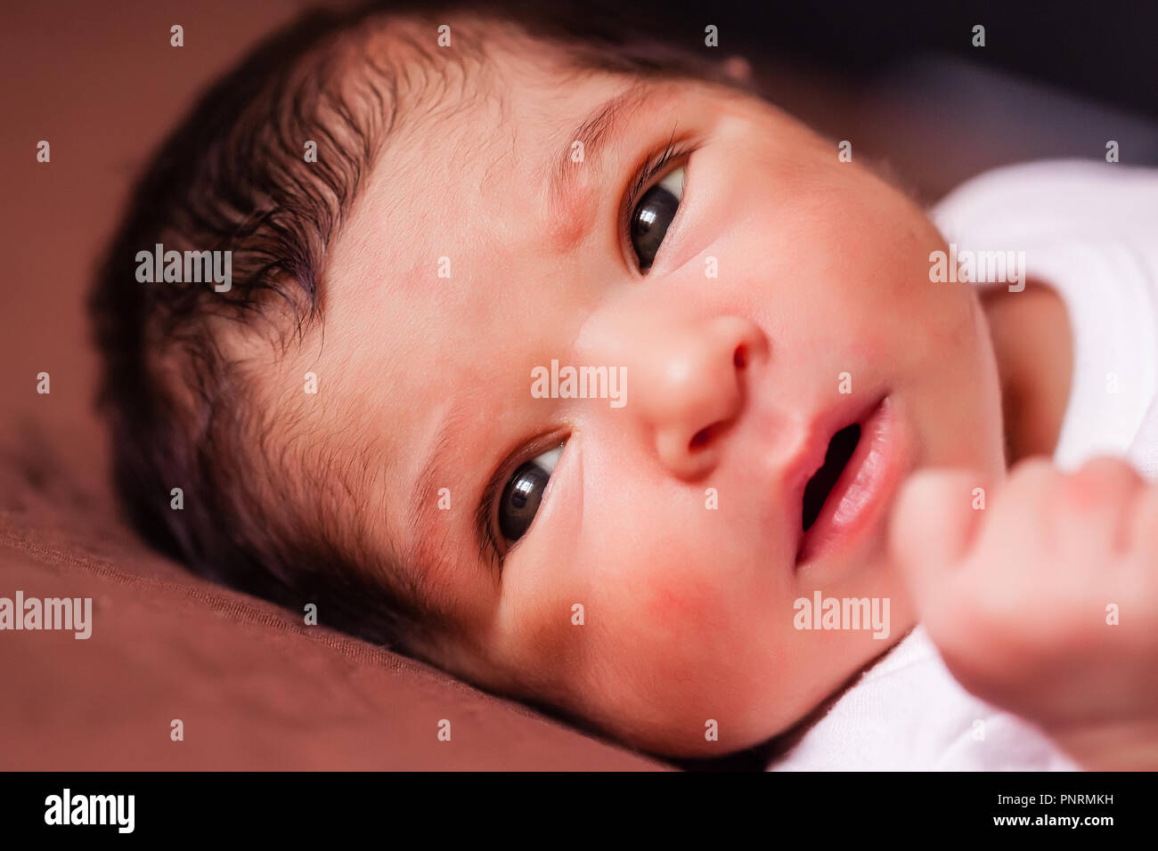 Nahaufnahme, Porträt einer niedlichen Zwei Wochen alte Neugeborene Mädchen liegend, mit offenen Augen und Suchen Stockfoto