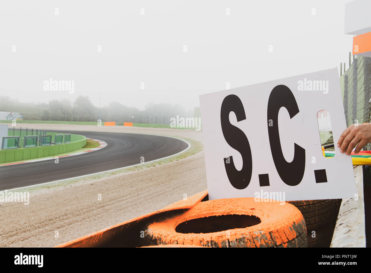 Nahaufnahme der menschlichen Hand, die Safety Car Warnung Signal board am Motor Sport Asphalt in den nebligen Tag Stockfoto