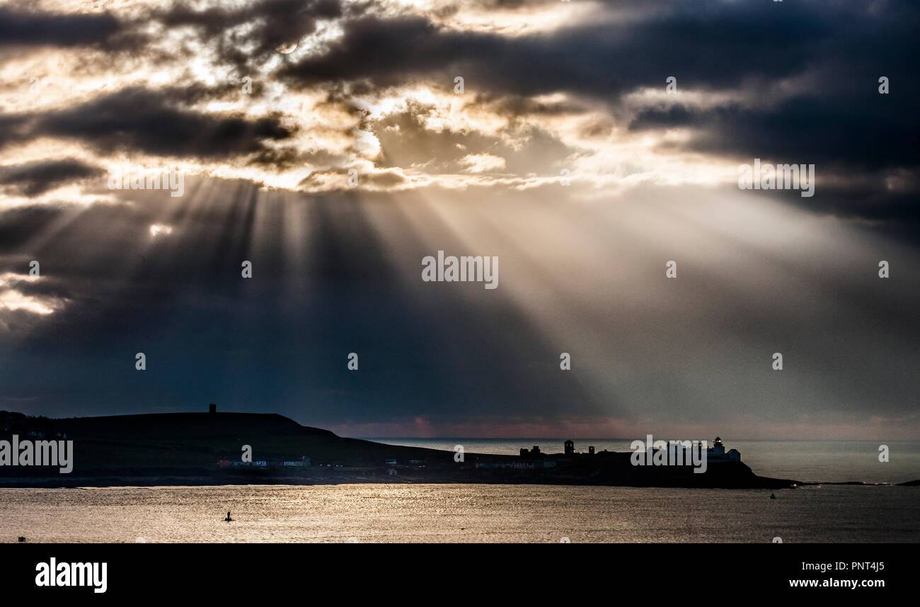 Roches Point, Cork, Irland. 27. Februar, 2018. Lichtstrahlen illumanate den Mund auf den Hafen und die Roches Point Lighthouse in Cork, Irland. Stockfoto