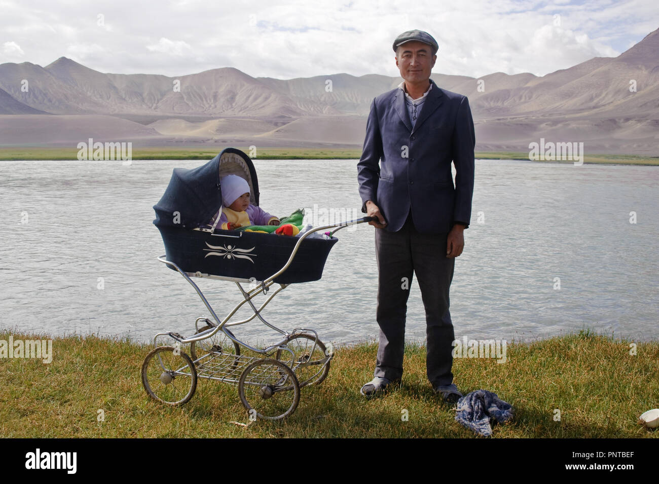 Kirgisische Vater, der sein Baby, für einen Spaziergang in die Hochebene von Pamir (Tadschikistan) Stockfoto