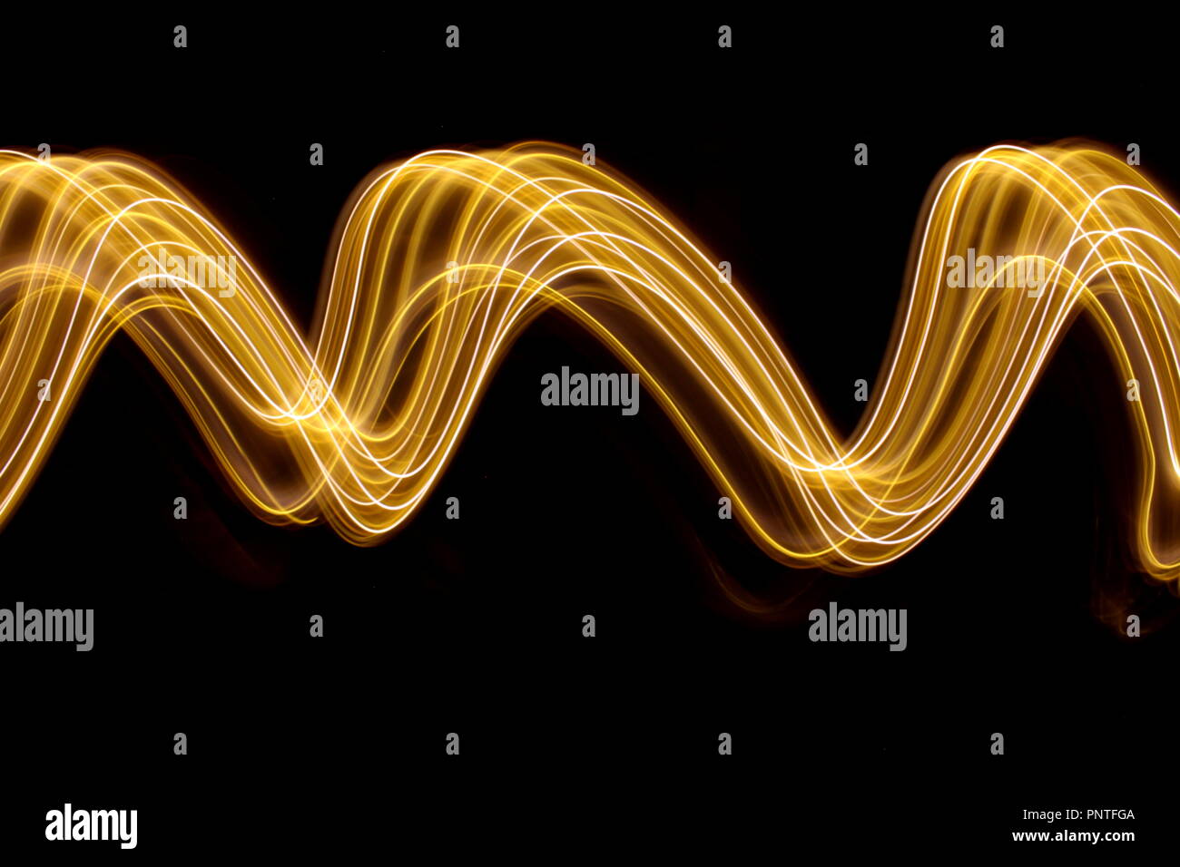 Licht Malerei Fotografie, lange Belichtung Foto von Gold Lichterketten in einem abstrakten Streifen von Lichtmuster auf schwarzem Hintergrund Stockfoto