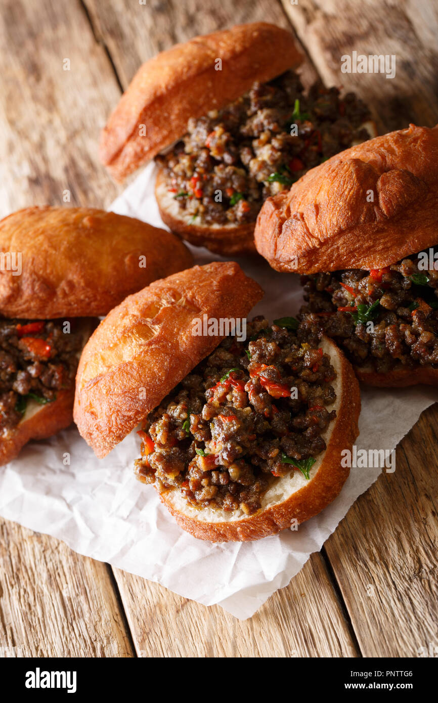 Afrikanische vetkoek frittierter Hefeteig gefüllt mit Fleisch in der Nähe Curry - auf den Tisch. Vertikale Stockfoto