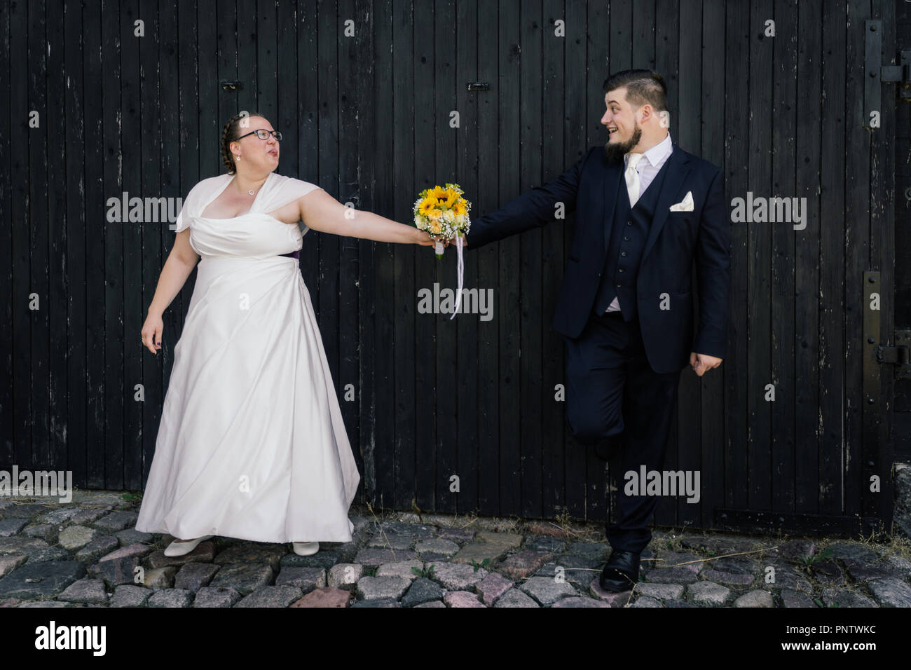 Braut und Bräutigam sind mit einem Blumenstrauß Stockfoto