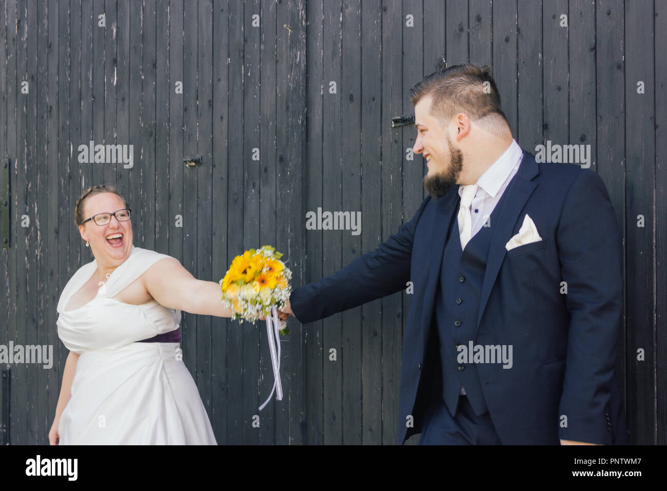 Braut und Bräutigam sind mit einem Blumenstrauß Stockfoto