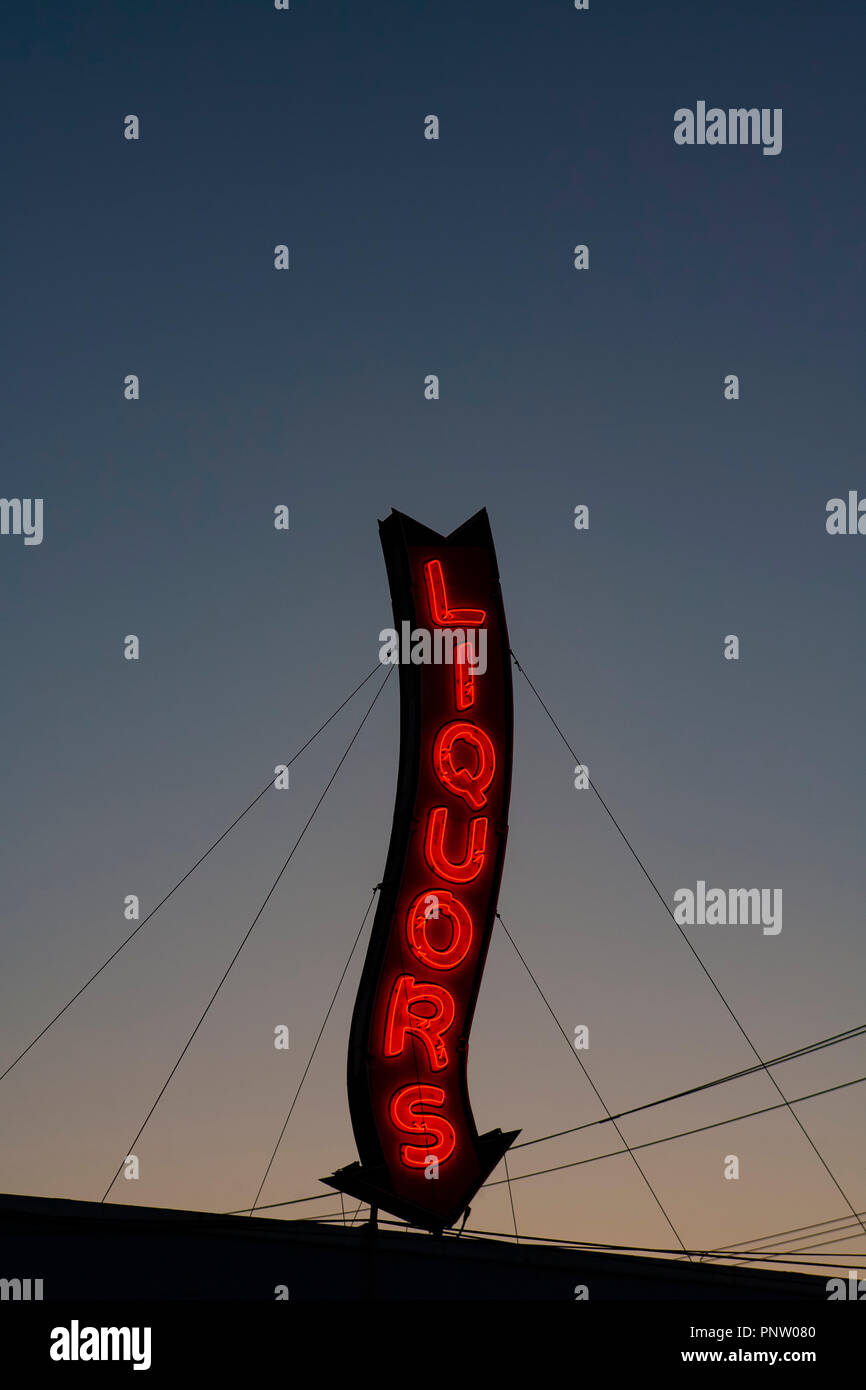 Ein Roter Neon Liköre Store anmelden glühende bei einem Sonnenuntergang. Stockfoto