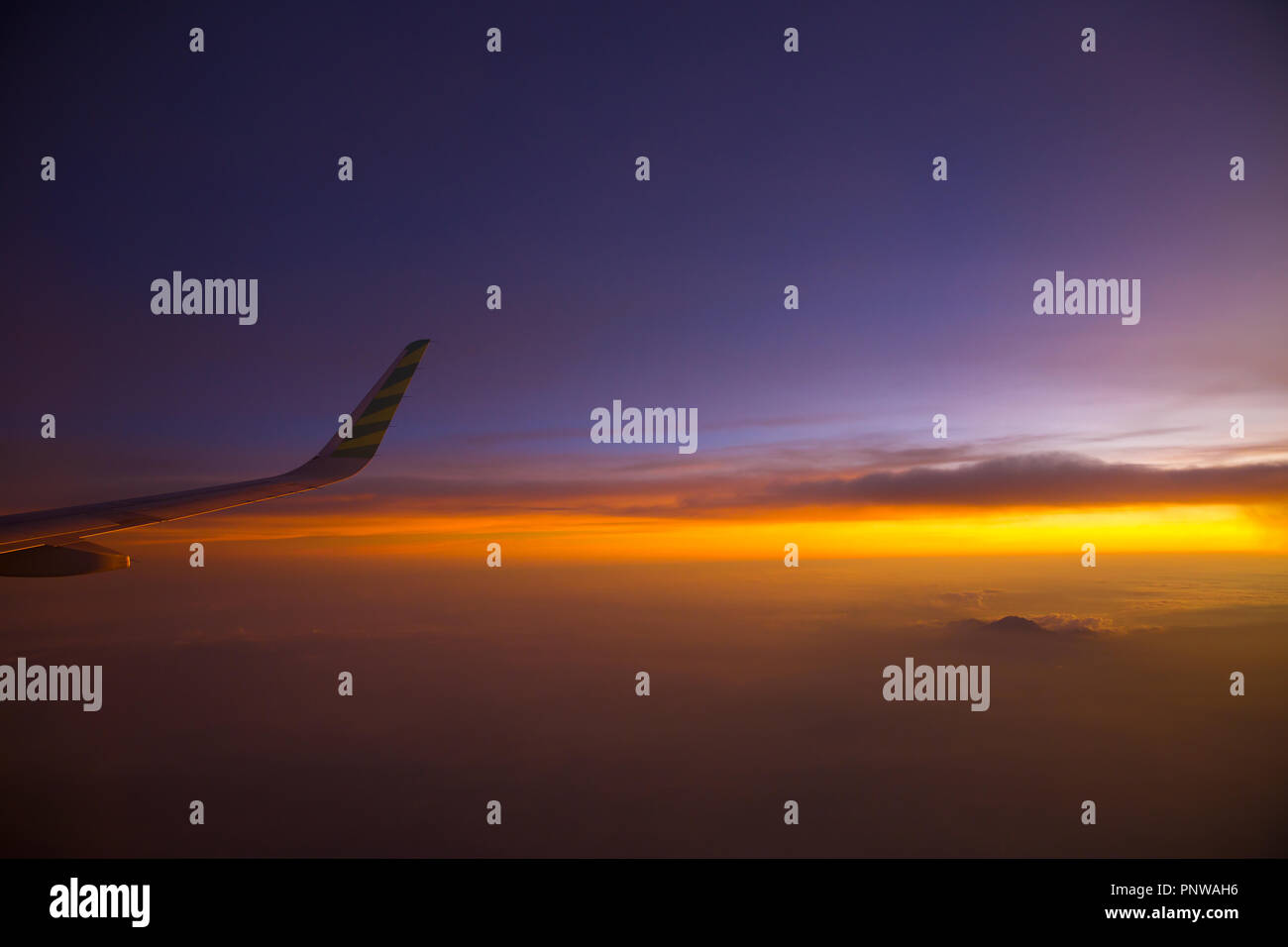 Fliegen und Reisen Konzept, Blick aus dem Flugzeug Fenster auf dem Flügel von der Sonnenuntergangszeit. Stockfoto