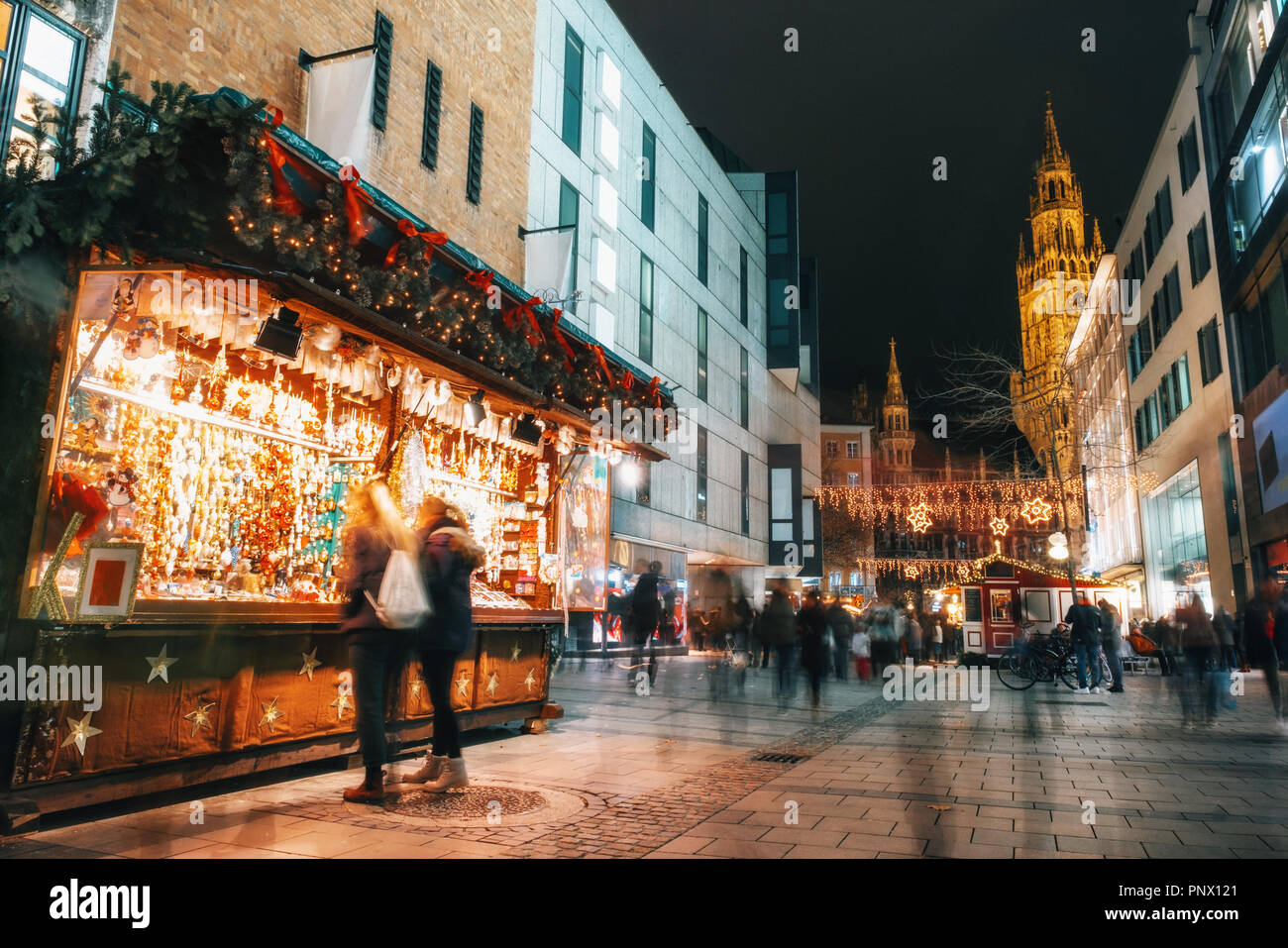 Verwischt die Menschen bewegt und Verkaufsstand auf dem Weihnachtsmarkt am Marienplatz vor dem Rathaus Neues Rathaus in München, Deutschland Stockfoto