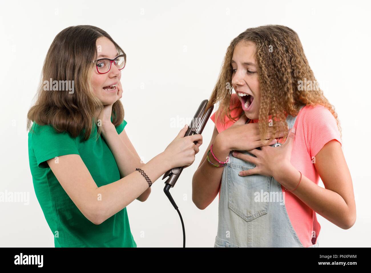 Portrait von zwei Jugendlichen Freundinnen Haarschnitt zuhause tun. Weißer Hintergrund. Stockfoto