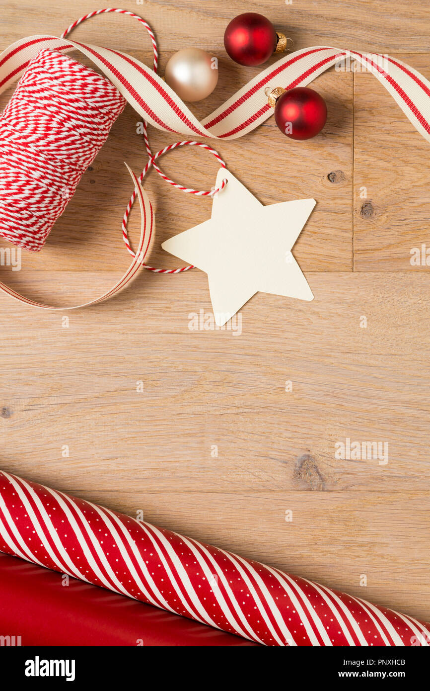 Einfache, Stil Land Weihnachten Geschenkpapier, Bänder, Dekorationen und leere Geschenkanhänger aus rustikalem Holz Hintergrund Stockfoto