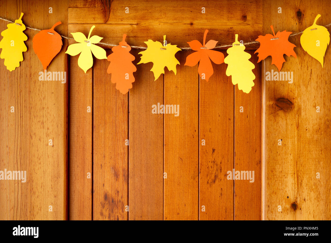 Einfachen, rustikalen Landhausstil Thanksgiving home Dekorationen Papier Handwerk Girlande banner Buntes Herbstlaub auf Holz Hintergrund Stockfoto