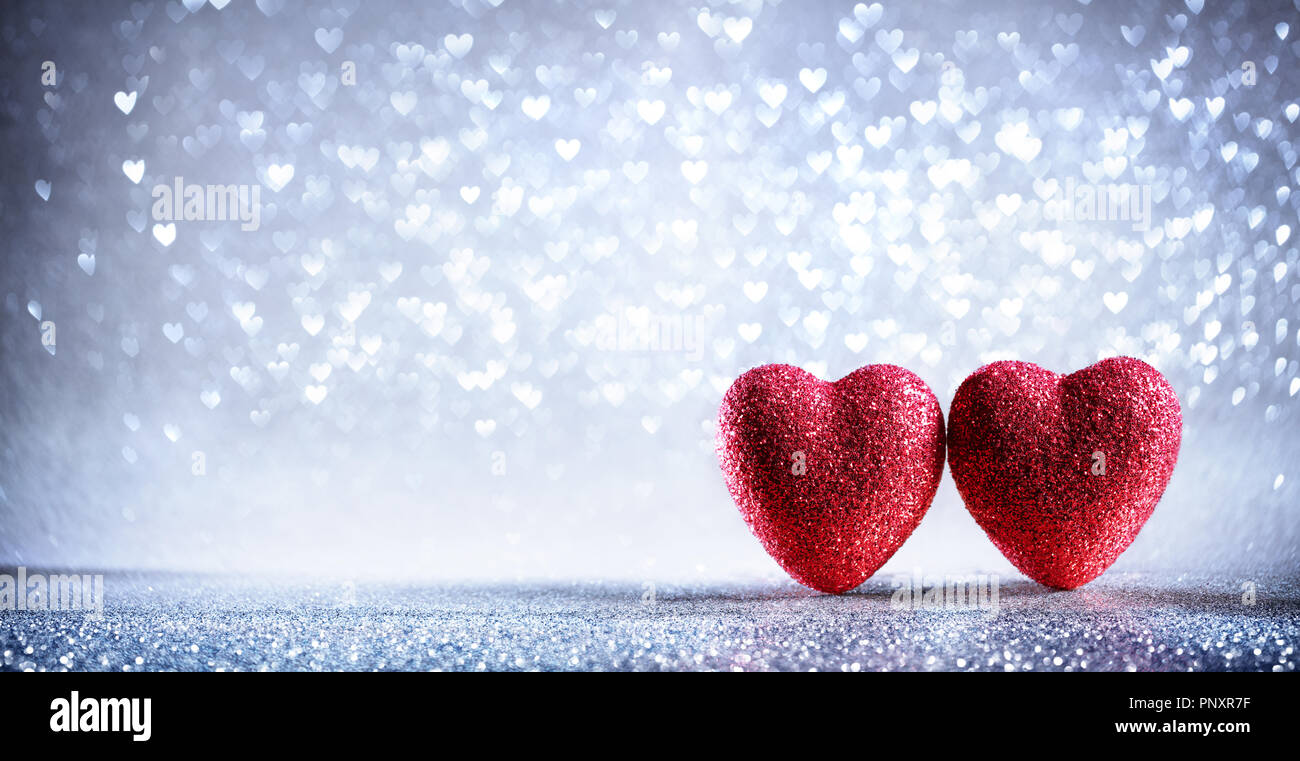 Valentines Card - Zwei Glänzende Herzen auf silbernem Hintergrund Stockfoto