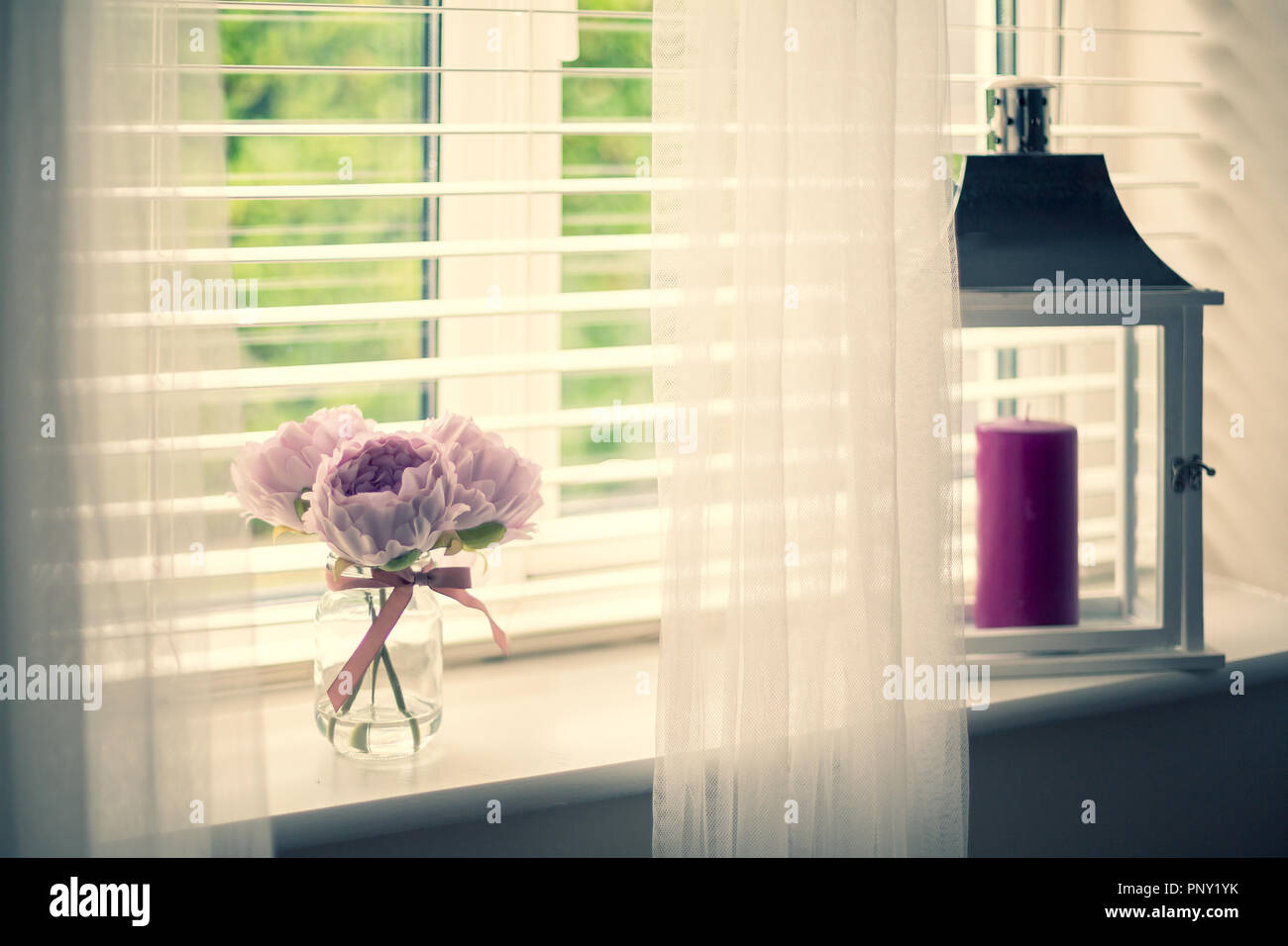 Home styling Fensterbank mit Gardinen, rosa Blüten und eine Laterne  eingerichtet Stockfotografie - Alamy