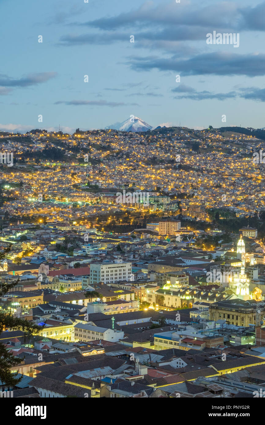 Blick auf Quito bei Nacht und den Vulkan Cotopaxi im Hintergrund, Ecuador Stockfoto