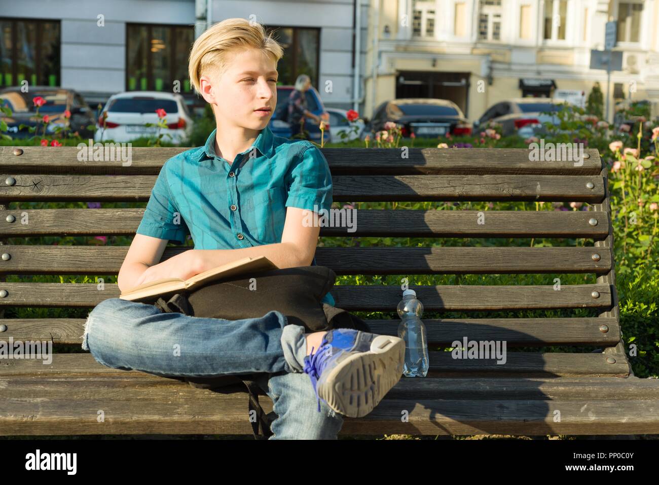 Outdoor Portrait von Teenager von 13, 14 Jahre alt, sitzt auf der Bank im City Park Stockfoto