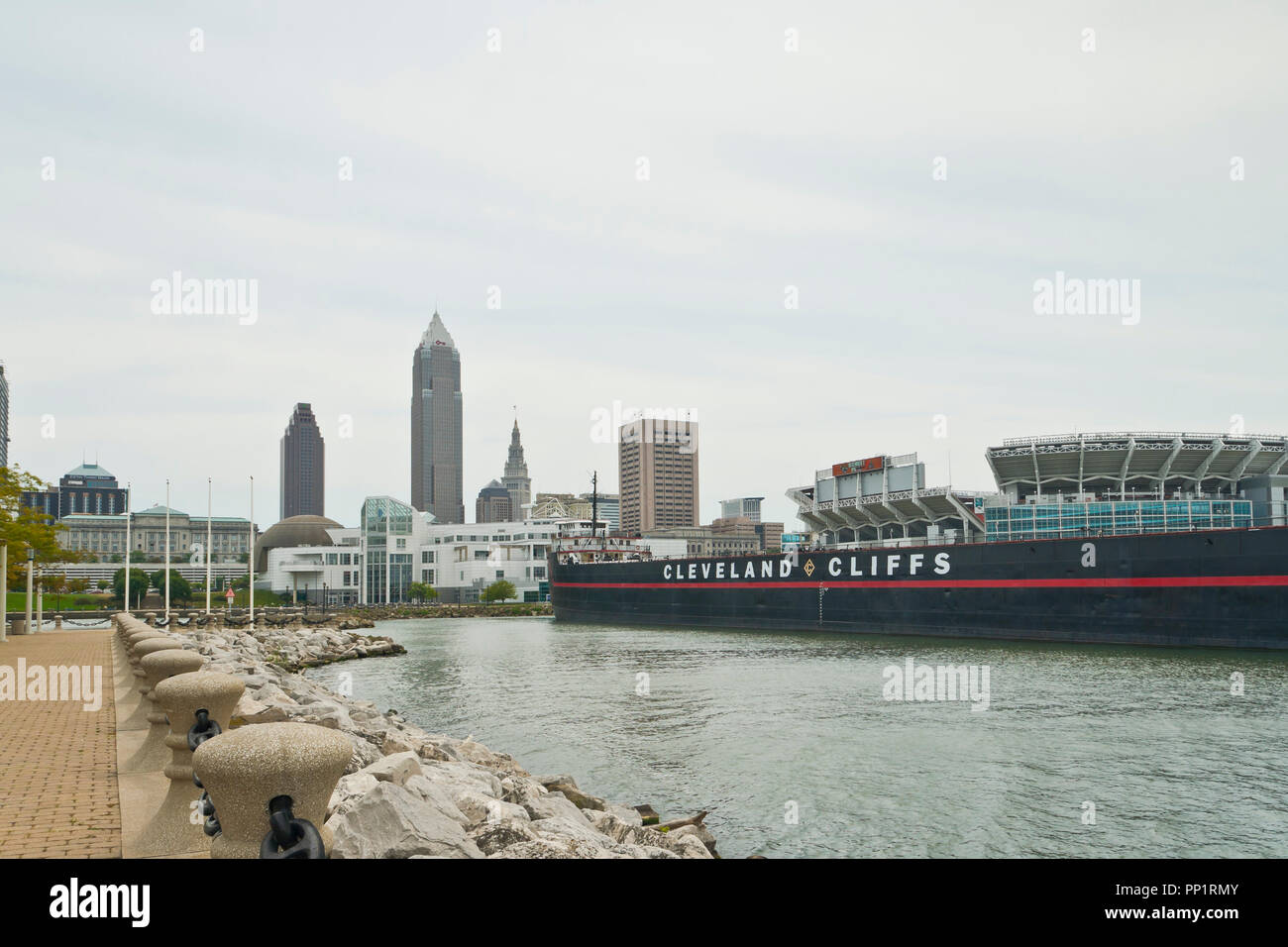 CLEVELAND - 26. August: Blick auf die Skyline von Cleveland Voinovich Park mit William G. Cleveland Cliffs' Mather Frachter auf einer überwiegend bewölkt s Stockfoto