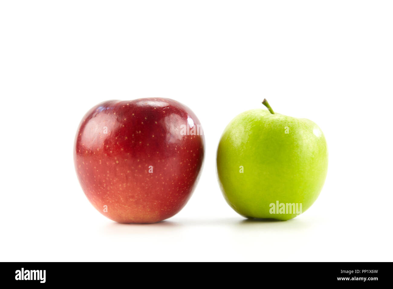 Zwei Äpfel eine Rot auf Grün auf weißem Hintergrund. Stockfoto
