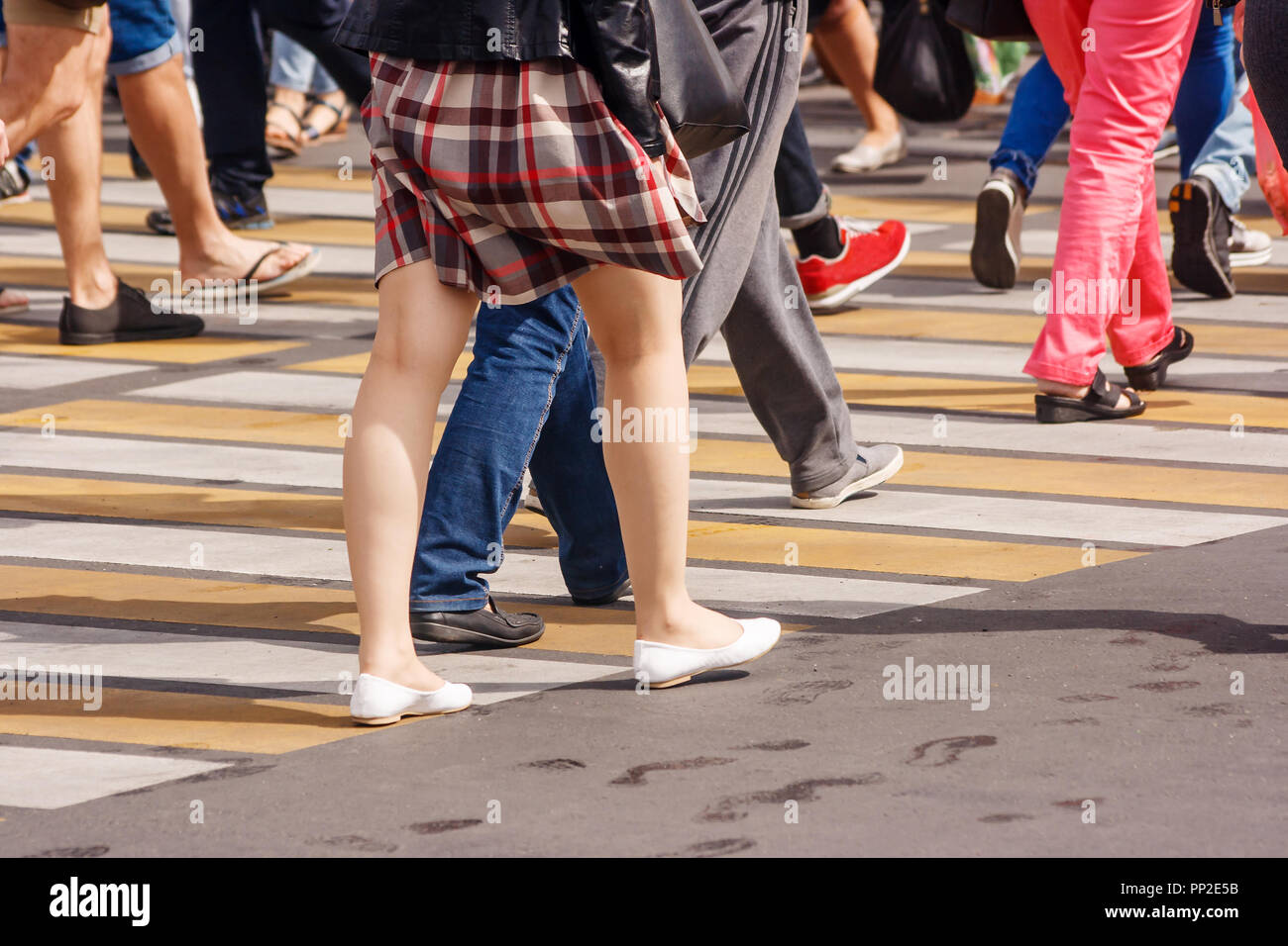 Viele Beine von Personen, die Fußgängerampel in der belebten Straße der Innenstadt an der sonnigen Sommertag Stockfoto