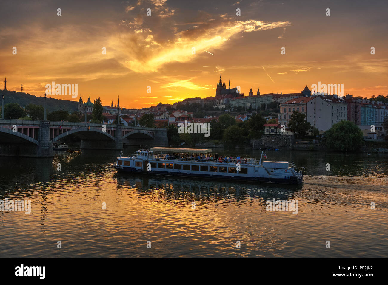 Prag, Tschechien - 19. September 2018: Bootsfahrt mit Touristen auf der Moldau schwimmt in Richtung der Manesuv Brücke mit Blick auf die Prager Burg bei Sonnen Stockfoto