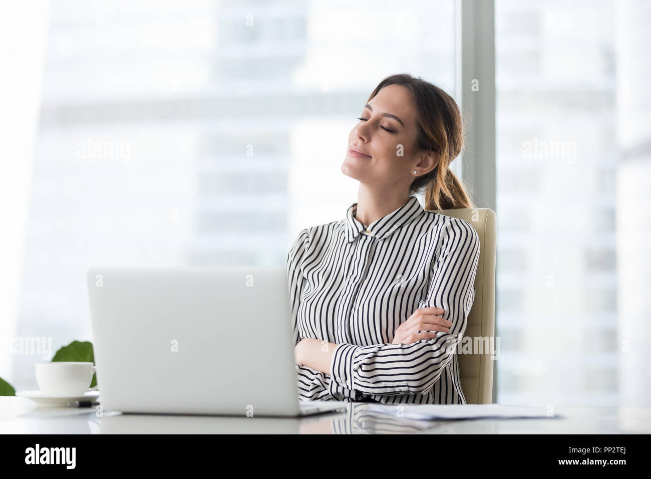 Lächelnd weibliche Boss entspannen im Bürostuhl mit geschlossenen Augen Stockfoto