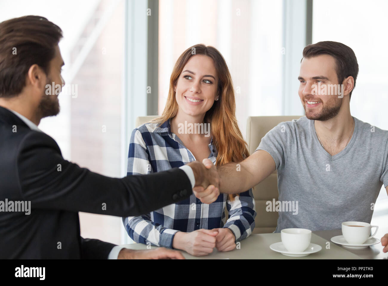 Glückliches Paar handshaking consulting Agent ihn besuchen im Büro Stockfoto