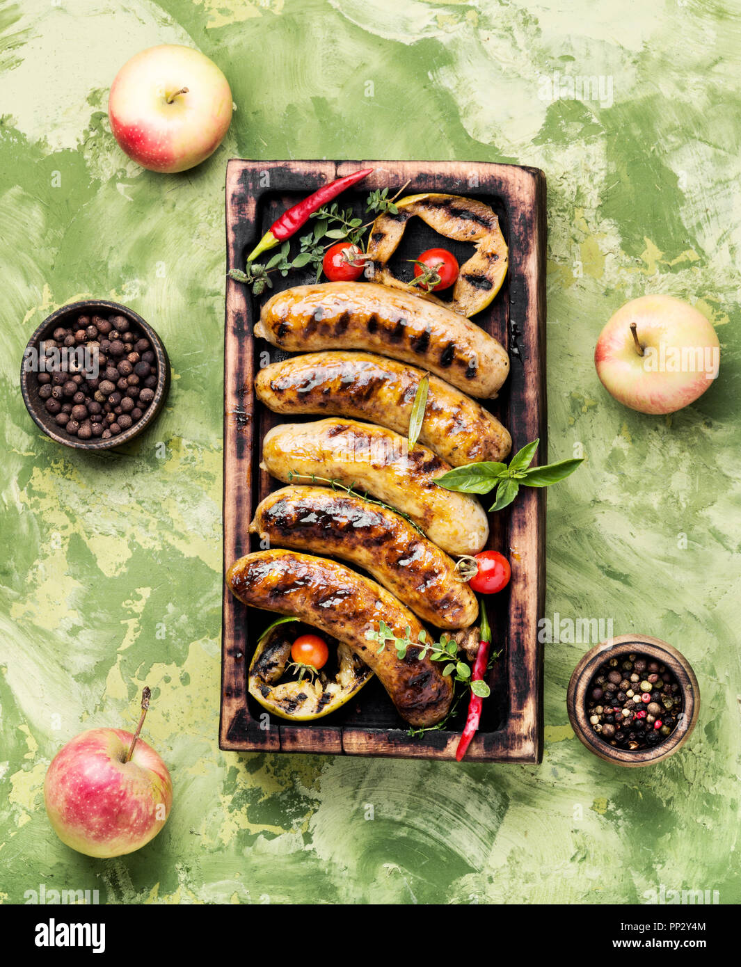 Leckere Würstchen vom Grill mit scharfen Gewürzen und Äpfel. BBQ Stockfoto