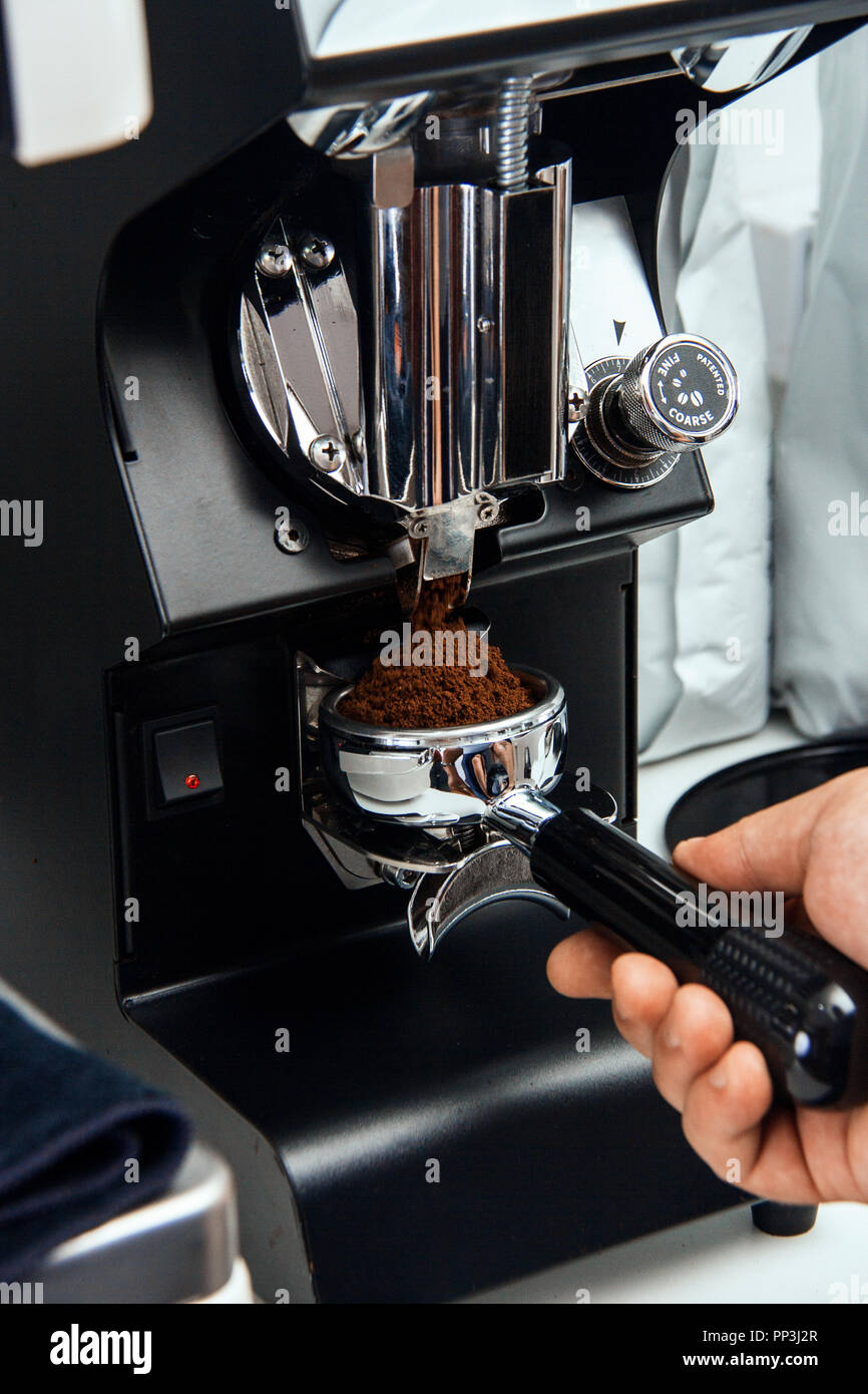 Frisch gemahlenen Kaffeebohnen in einem portafilter durch die Kaffeemühle Stockfoto