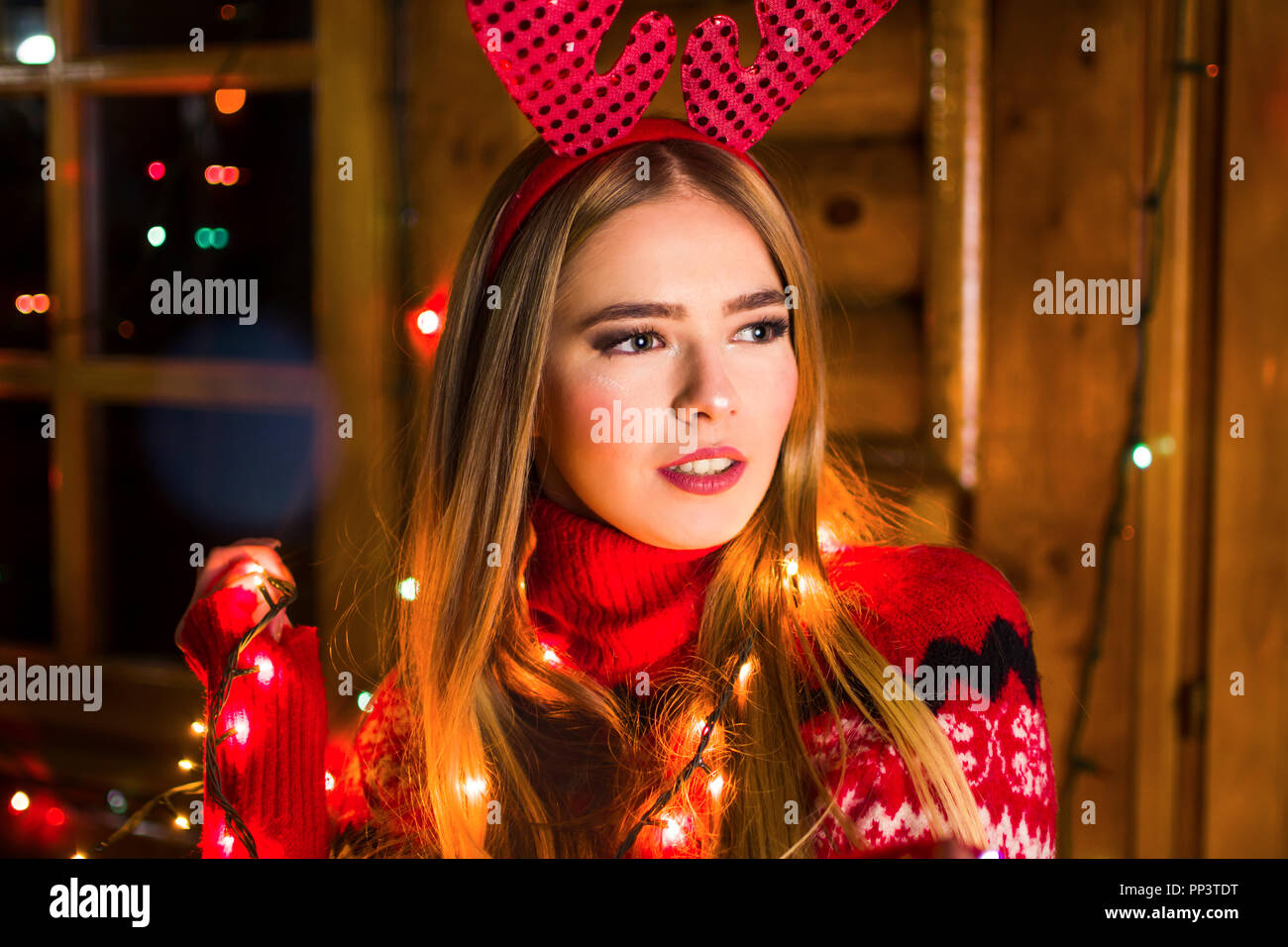 Schöne Mädchen mit festliche Lichter in einem Blockhaus Stockfoto