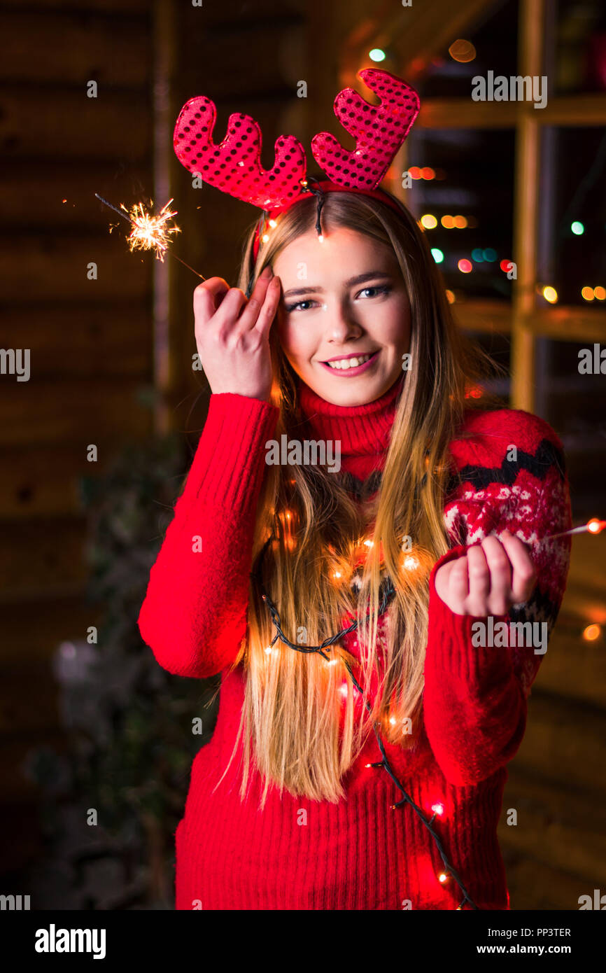 Schöne Mädchen mit festliche Lichter in einem Blockhaus Stockfoto