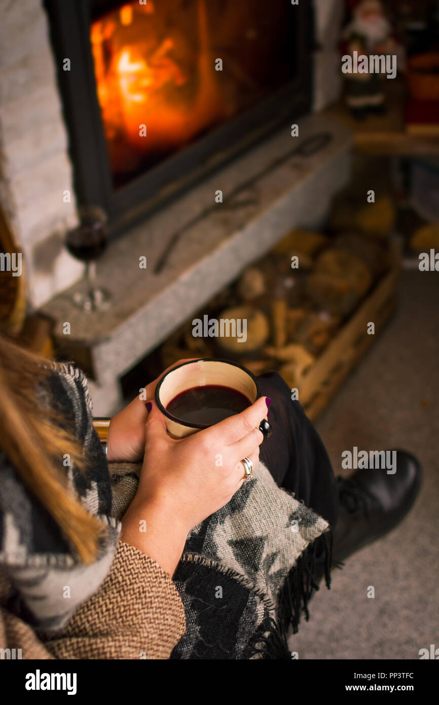 Frau trinkt Glühwein am Kamin, winter Lifestyle Stockfoto