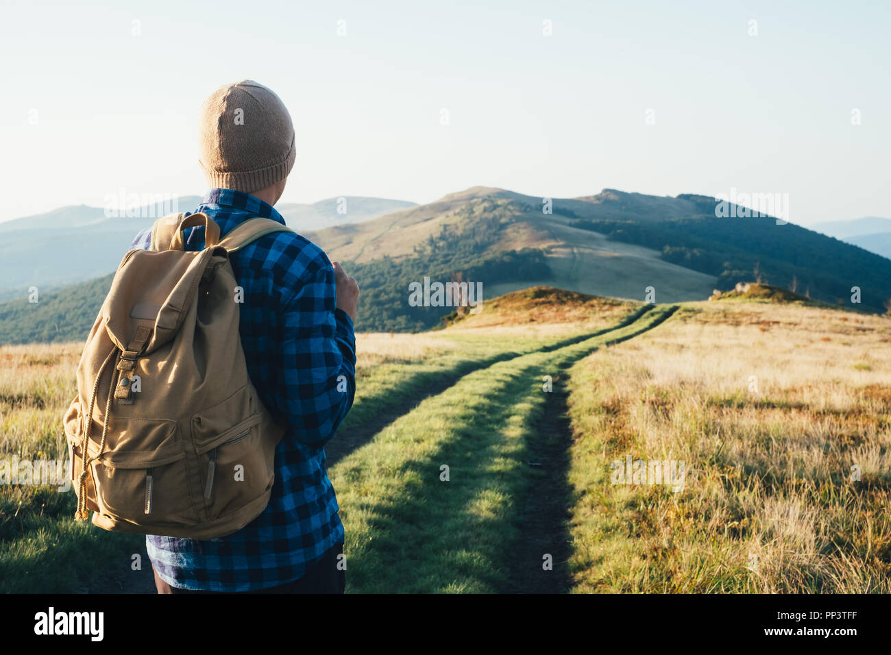 Mann mit Rucksack auf Berge Straße. Travel Concept. Landschaftsfotografie Stockfoto