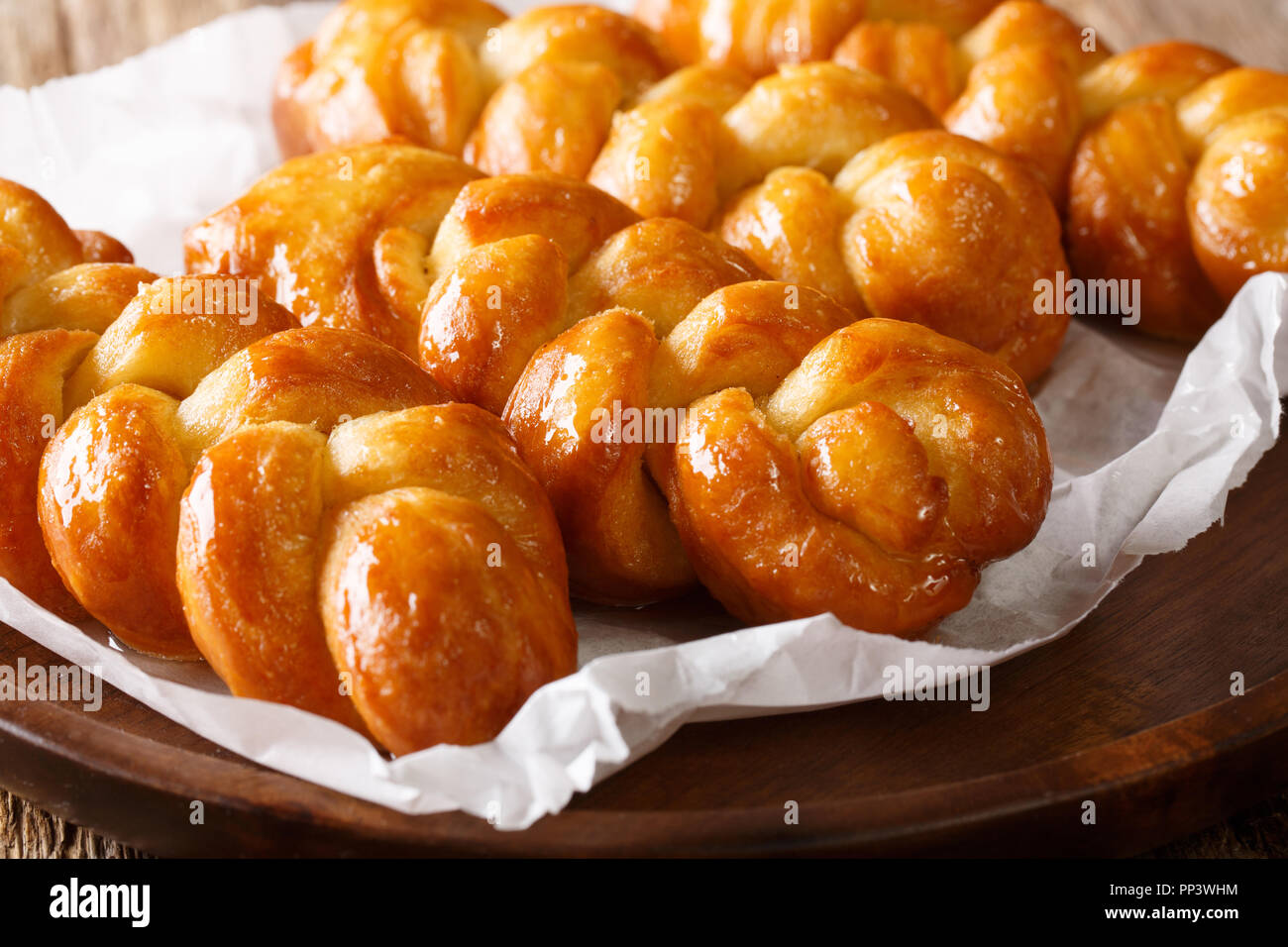 Traditionelle Südafrikanische klebrige Donut Koeksisters behandeln das ist köstlich Süß, klebrig, knackig und in Sirup Makro auf einem Teller durchnässt. Horizontale Stockfoto