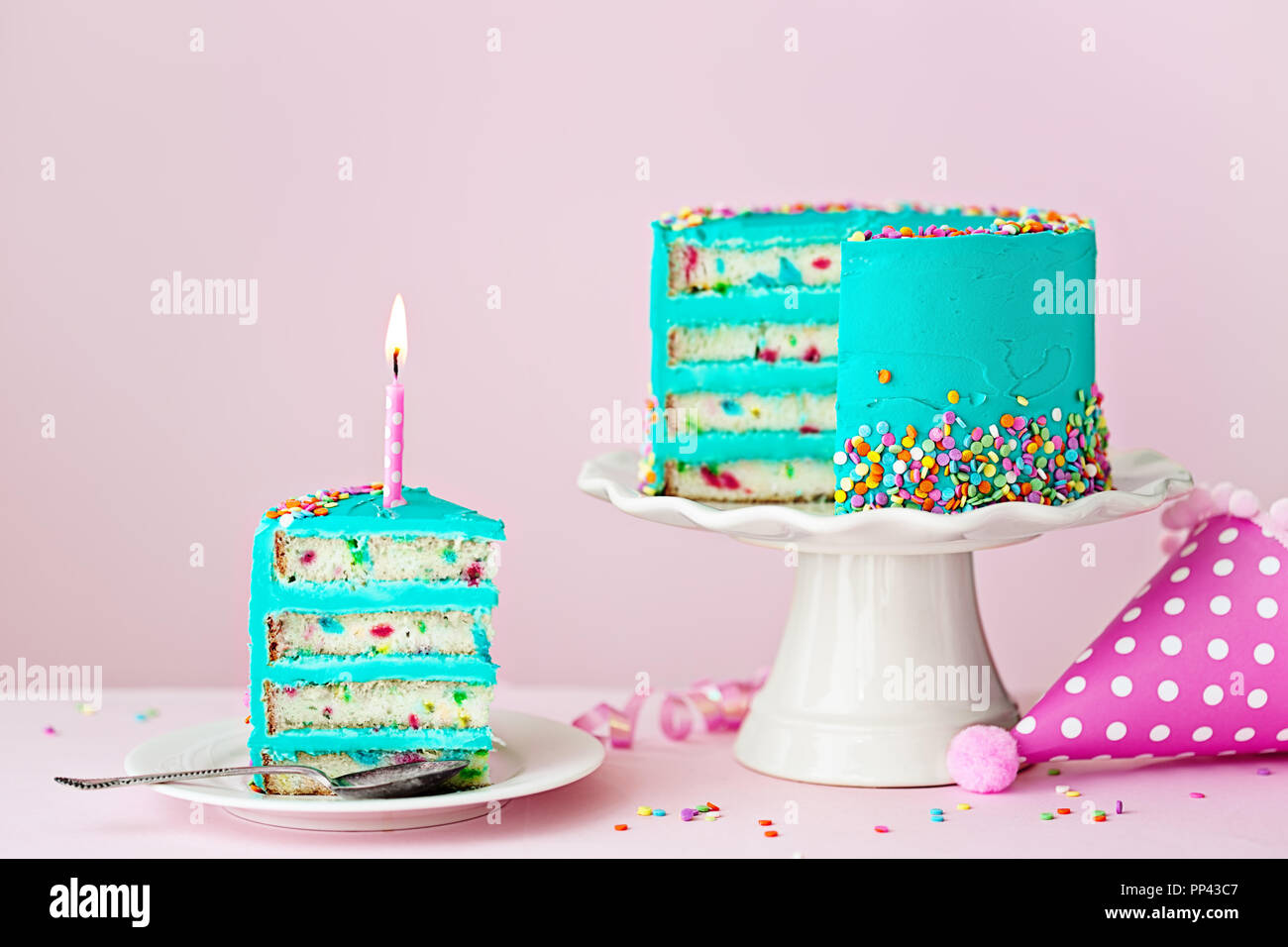 Bunter Geburtstagskuchen mit einer Scheibe und eine Kerze Stockfoto