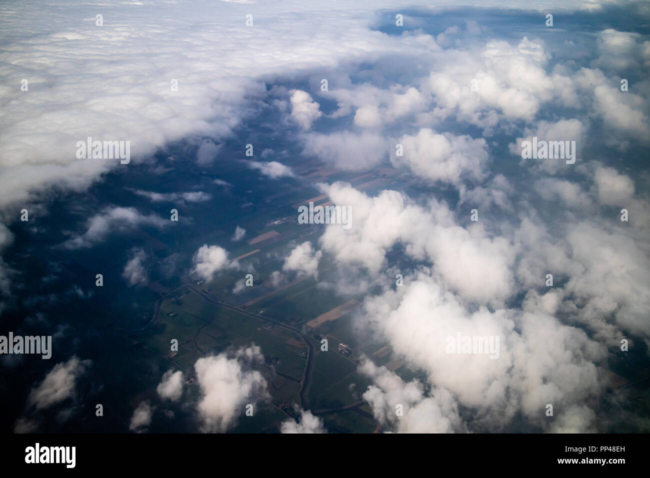 Ein Luftbild der Felder und Ebenen unter einem Meer von Wolken Stockfoto