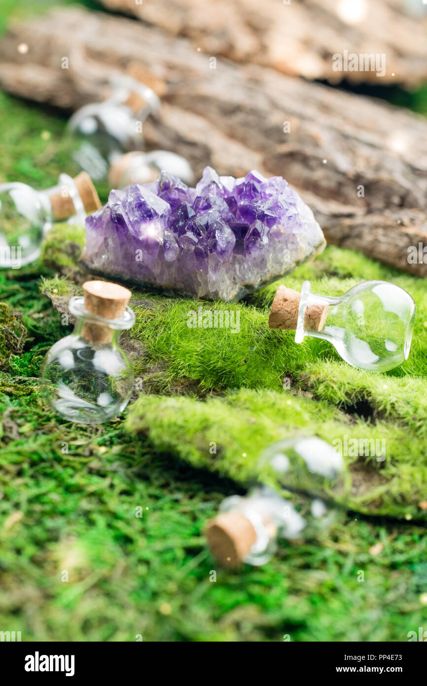 Magic Flasche und Amethyst Stein auf Emerald Moos im Wald. Halloween Theme. Stockfoto