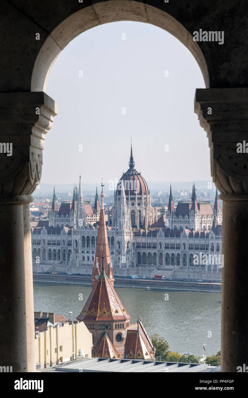 Das ungarische Parlament Gebäude durch den Bögen der Fischerbastei auf dem Burgberg von Budapest gesehen Stockfoto