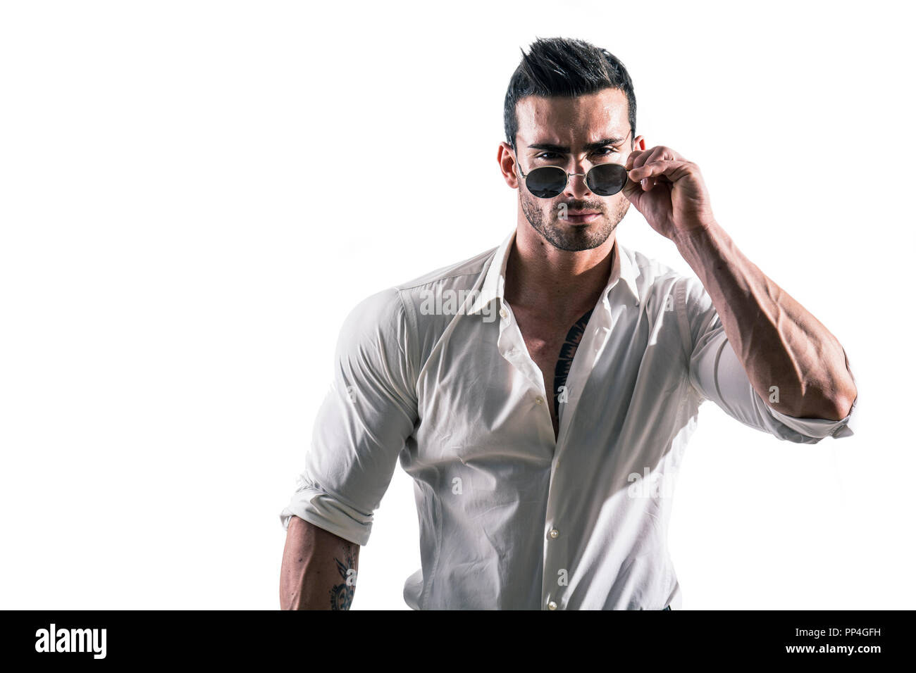 Portrait von Brünette junge Mann im weißen Hemd und Sonnenbrille, stehend im Studio shot vor weißem Hintergrund. Volle Länge Foto Stockfoto