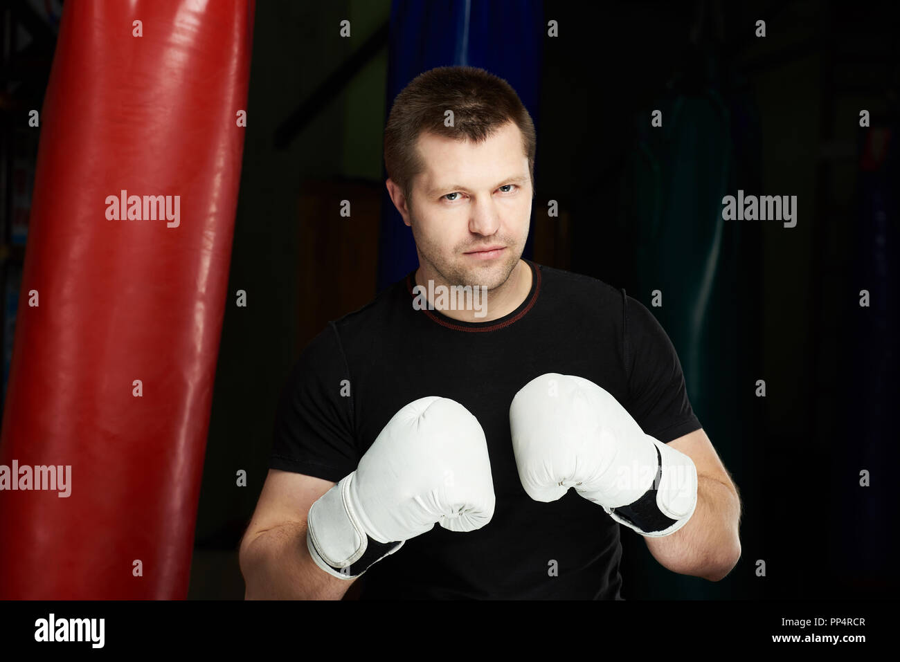 Junge Mann kaukasischen Boxer mit weißen Handschuhen stehen auf der moderne Fitnessraum Hintergrund Stockfoto