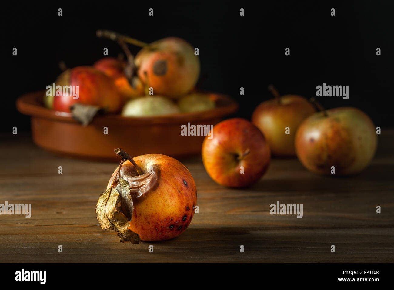 Echte und organische faule Äpfel auf einem Holztisch Stockfoto