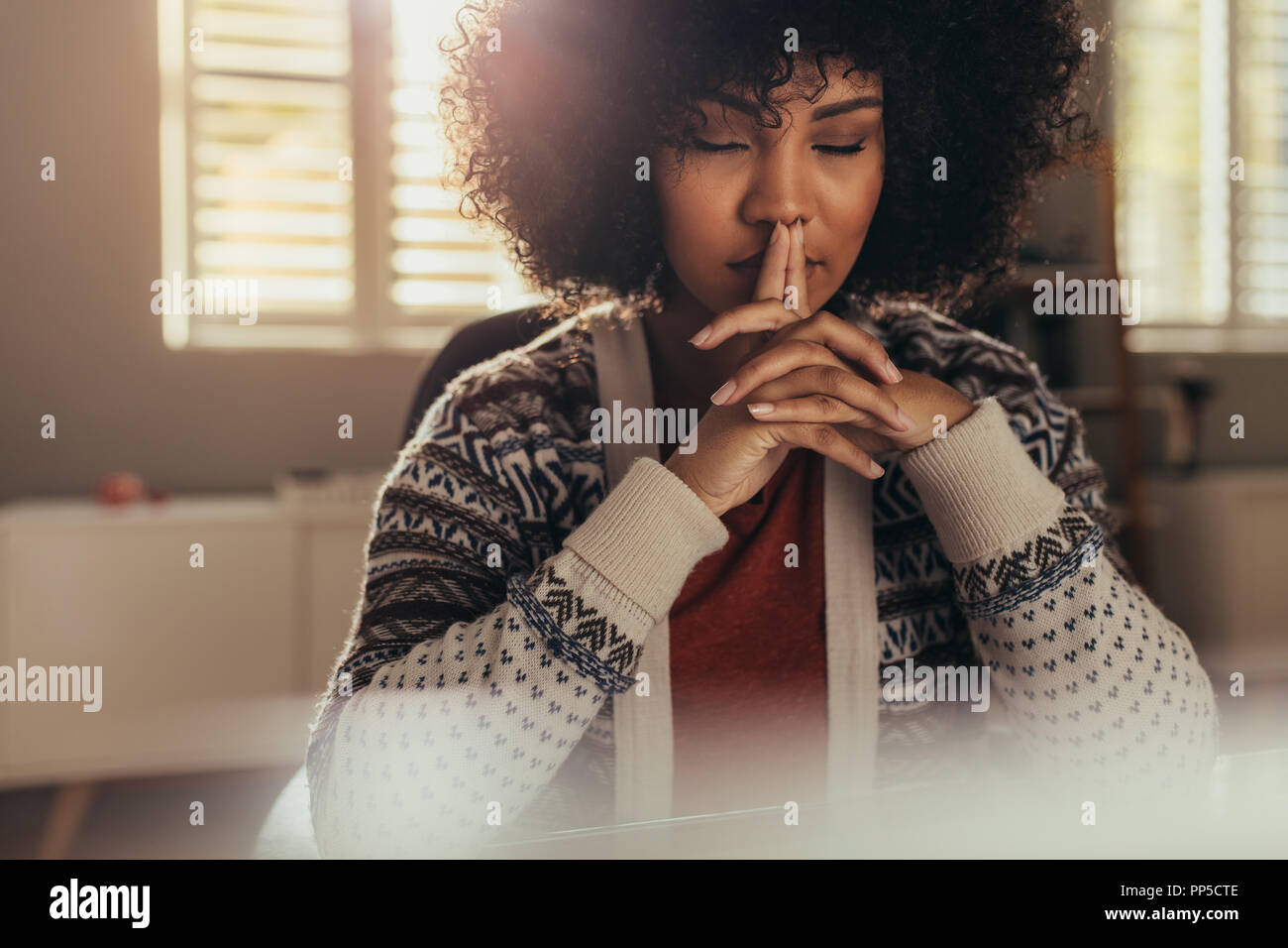 Afrikanische Frauen sitzen an Ihrem Schreibtisch und denken mit geschlossenen Augen. Betonte Frau eine Pause mit Lösung mit Achtsamkeit zu kommen. Stockfoto