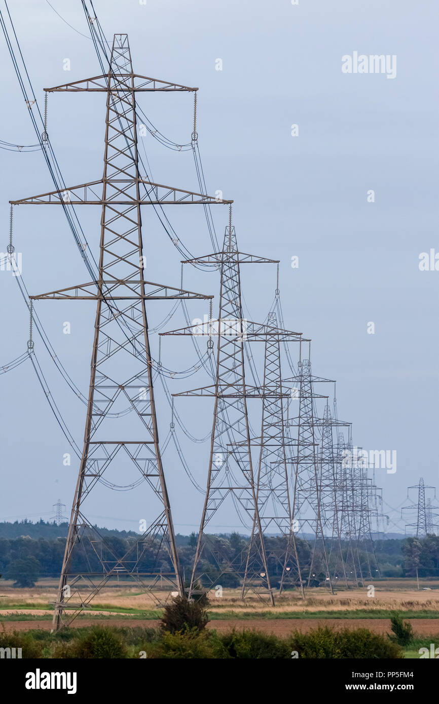 Strommasten oder Sendemasten, Hochspannungsleitungen und Freileitungen über Land als Teil der nationalen Grid-Netzwerk Stromversorgung Stockfoto