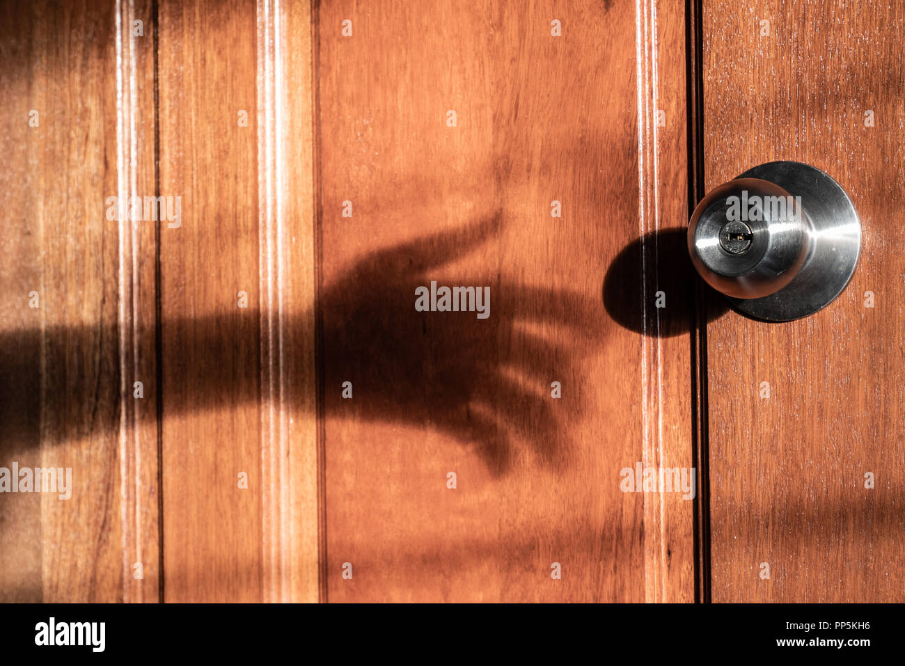 Schatten der Hand Einbrecher versucht, die Tür zu öffnen Stockfoto