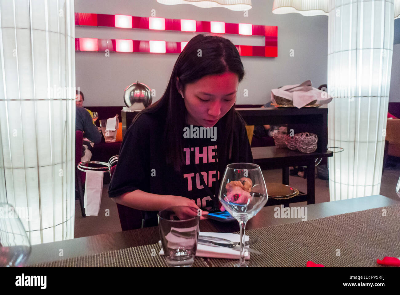 Marseille, Frankreich, Chinesische Touristen insdie lokalen französischen Bistro Restaurant in der Nähe des Old Port. Frau mit Smart Phone am Tisch Stockfoto