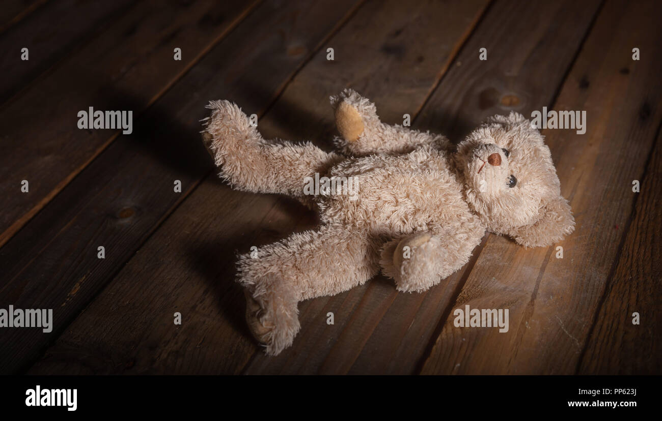 Kindesmissbrauch Konzept. Teddybär am Boden, dunkle Holz- Hintergrund Stockfoto